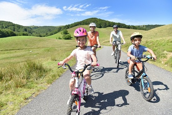 Familia paseando por el campo en bici: modelo de turismo sostenible